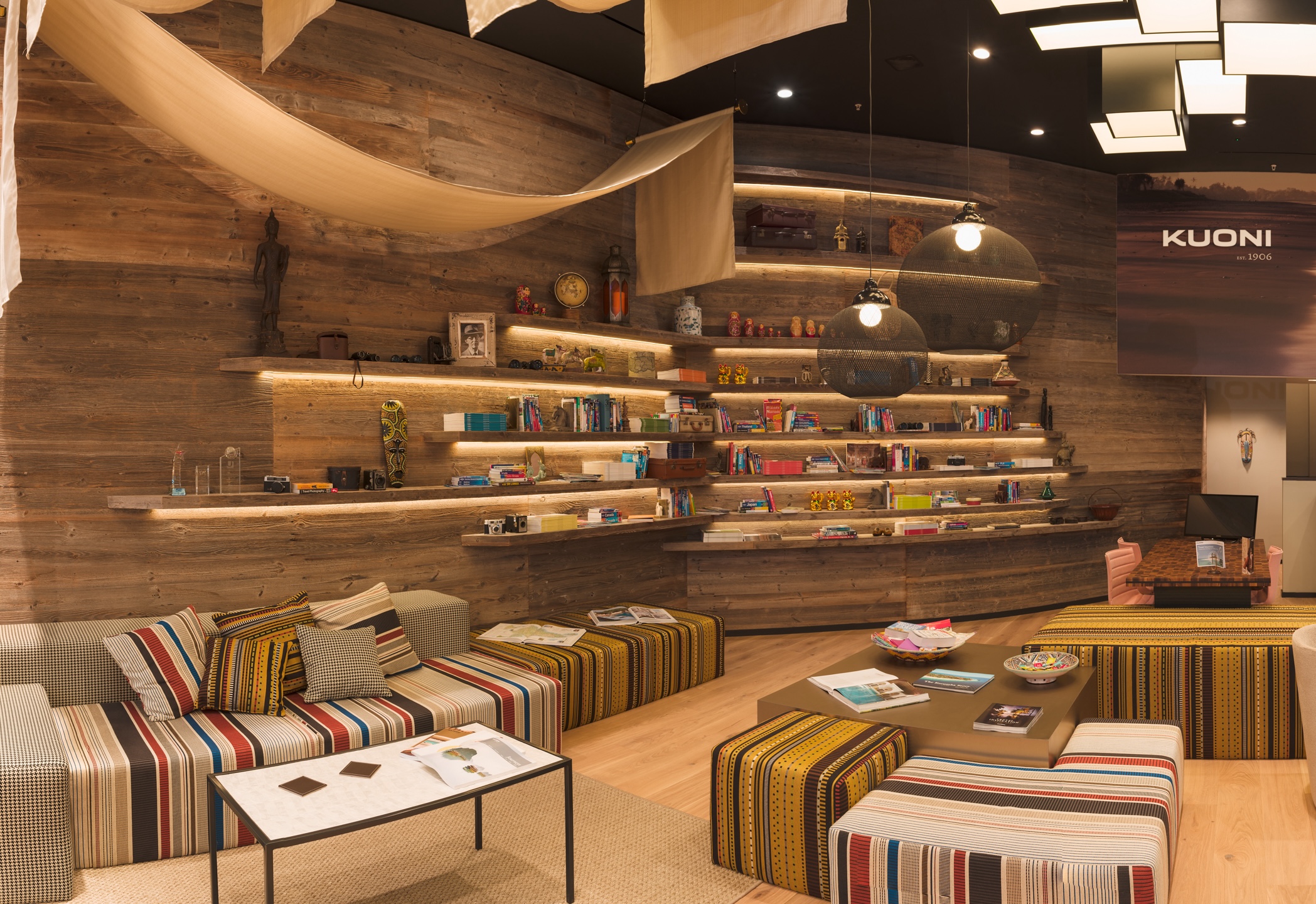 Kuoni Travel retail store interior with warm LED shelf lighting highlighting books, décor and travel displays